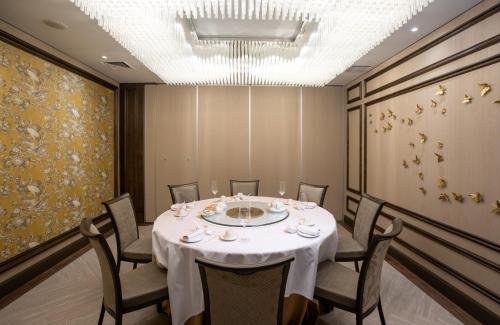 a dining room with a white table and chairs at AYANA Midplaza JAKARTA in Jakarta