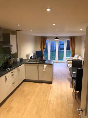 a kitchen and a living room with a couch at San Pedro Lodge Sittingbourne in Kent