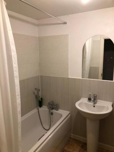a bathroom with a sink and a bath tub and a sink at San Pedro Lodge Sittingbourne in Kent