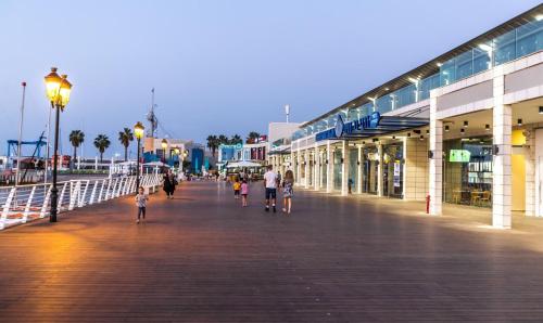 a group of people walking down a boardwalk at Rotem Suite in MARINA ASHKLON in Ashqelon