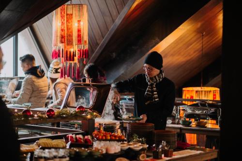 een vrouw die eten klaarmaakt in een restaurantkeuken bij Sapa Jade Hill Resort & Spa in Sa Pa