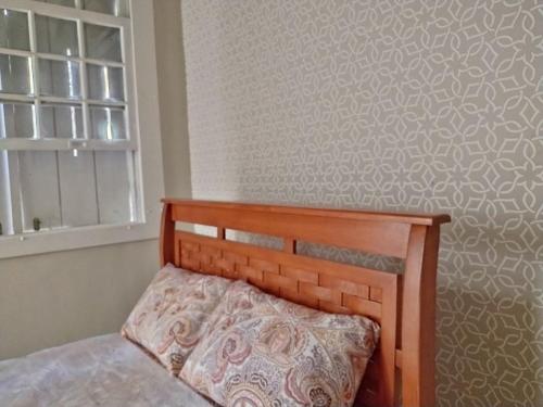 uma cama com uma cabeceira de madeira num quarto em Mansão de Pirah Suites em Niterói