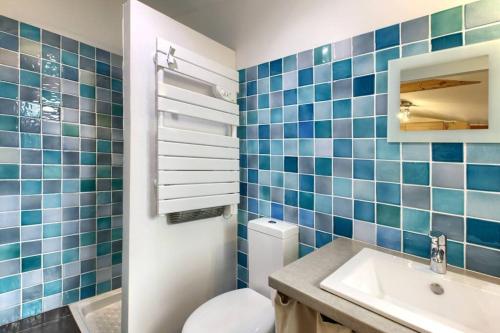 a blue tiled bathroom with a toilet and a sink at 6 personnes, 2 studios indépendants avec terrasse. in Arcachon