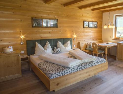 1 dormitorio con 1 cama en una habitación de madera en Stifterhof, en Villabassa