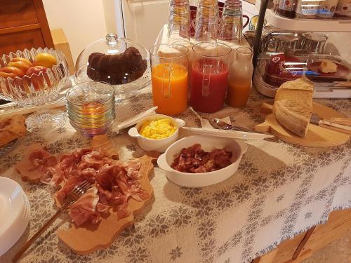 a table topped with breakfast foods and orange juice at B&B SognoInCadore in Domegge di Cadore