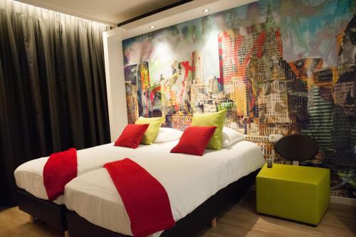 a bedroom with a large bed with a painting on the wall at Appart'hotel Urban Lodge in Chaudfontaine