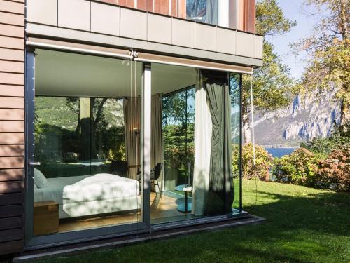a glass house with a view of the water at Casa Sull'Albero in Malgrate