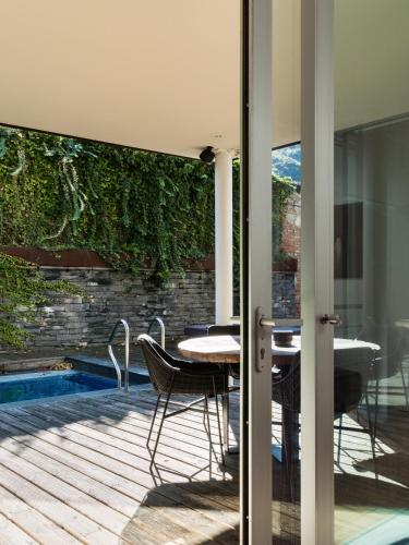 a patio with a table and chairs next to a pool at Casa Sull'Albero in Malgrate