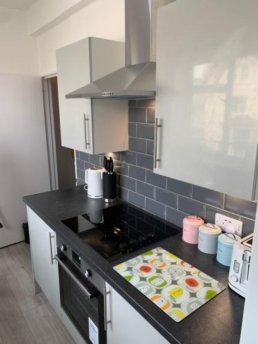 a kitchen with a black counter top with a stove at Eastbourne Town centre Maisonette apartment in Eastbourne