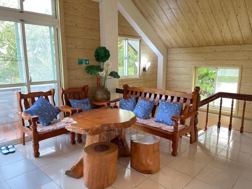 a room with a wooden table and benches and a table with pillows at Sao Ba Ding Homestay in Ruisui