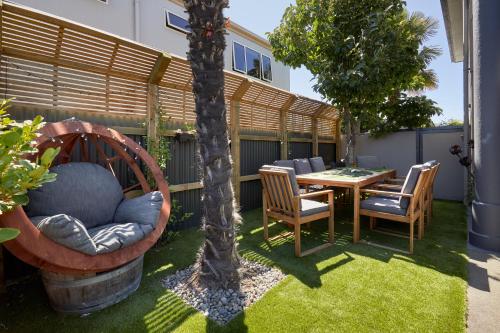 a patio with a table and chairs and a tree at Blenheim Palms Motel in Blenheim