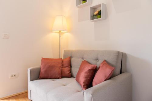 a living room with a couch with three pillows at Studio Apartment Vittoria in Lovran