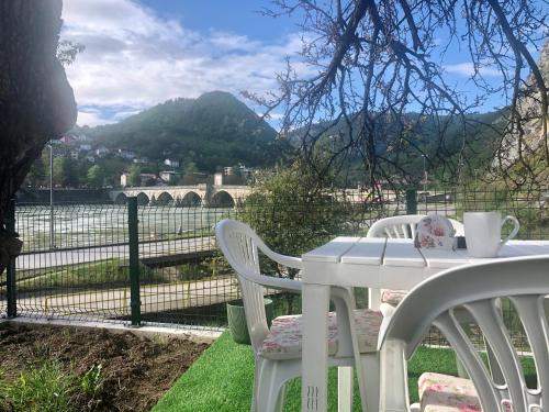 a white table and chairs with a view of a mountain at Ive Andrica 3 in Višegrad