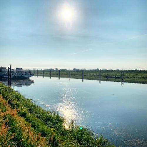 a river with a boat in the water at Ringhotel Schloss Tangermünde in Tangermünde