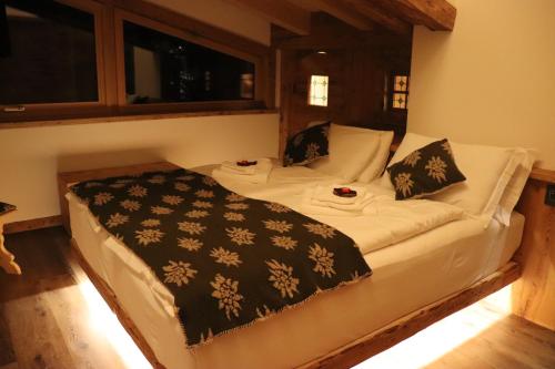 a bedroom with a bed in a room with windows at Hotel Ciasa Lorenzi in Cortina dʼAmpezzo