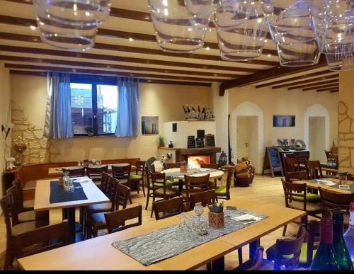 ein Restaurant mit Holztischen und -stühlen und ein Zimmer mit Fenstern in der Unterkunft Ferienzimmer Weingut Mack in Oestrich-Winkel