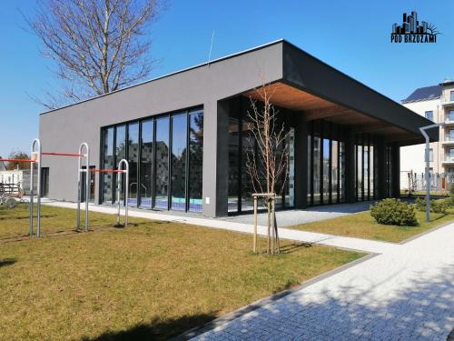 a building with a black roof and windows at Pod Brzozami Apartamenty 5 Mórz in Ustronie Morskie