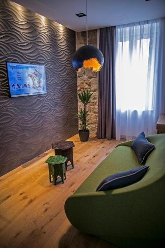 a living room with a green couch and a window at Rooms Lejletul in Split