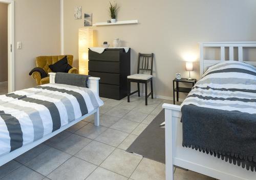 a bedroom with two beds and a dresser at Harz Living in Clausthal-Zellerfeld