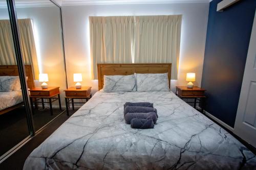 a bedroom with a large bed with two lamps on two tables at Wavecrest Village & Tourist Park in Hopetoun