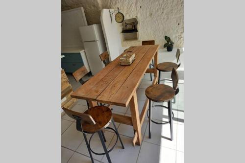 a wooden table and chairs in a kitchen at La Trog'Laudy gîte 4 étoiles au coeur des vignes in Vouvray