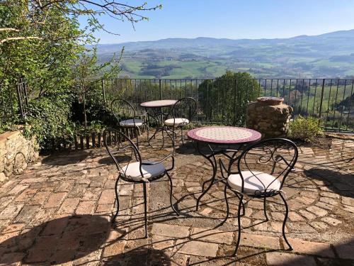 a group of chairs and tables on a patio with a view at Lemon Tree Boutique Guest House in Todi