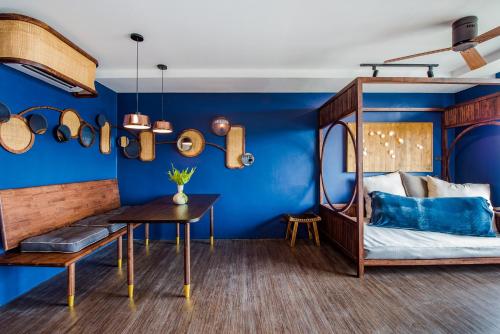 a bedroom with blue walls and a bed with a desk at Seamira House Huahin in Hua Hin