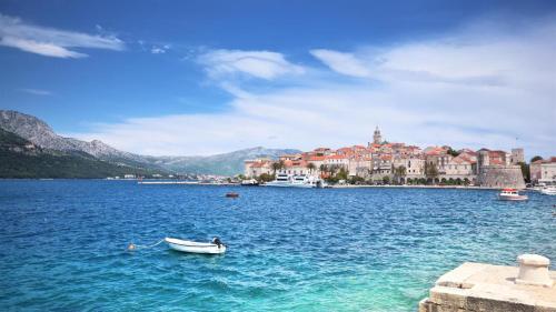 a boat in a large body of water with a town at Nata in Korčula