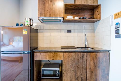 a kitchen with a sink and a refrigerator at Seamira House Huahin in Hua Hin