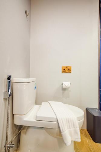 a bathroom with a white toilet with a towel on it at Seamira House Huahin in Hua Hin