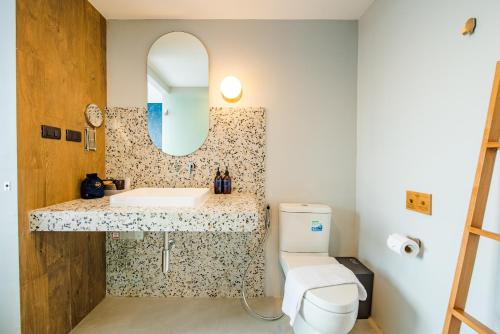 a bathroom with a sink and a mirror and a toilet at Seamira House Huahin in Hua Hin