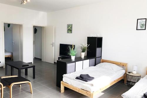 a bedroom with a bed and a table and chairs at Work & Stay Apartments in Euskirchen in Euskirchen