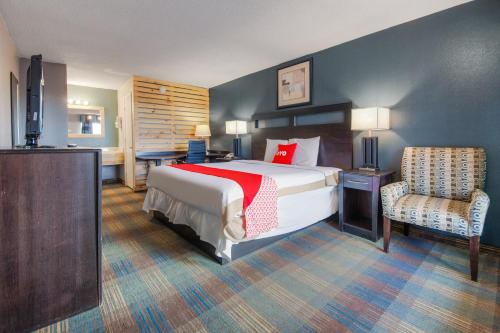 a hotel room with a bed and a chair at Capital O 3Y Motel Mount Vernon Renfro Valley in Mount Vernon