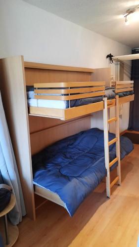a bedroom with two bunk beds with blue sheets at Cap plein sud en ubaye in Barcelonnette