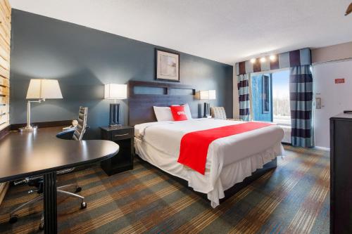 Una habitación de hotel con una cama grande y un escritorio. en Capital O 3Y Motel Mount Vernon Renfro Valley, en Mount Vernon