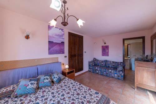 een slaapkamer met een bed en een bank bij Casetta Marì immersa in un vigneto in Dolceacqua