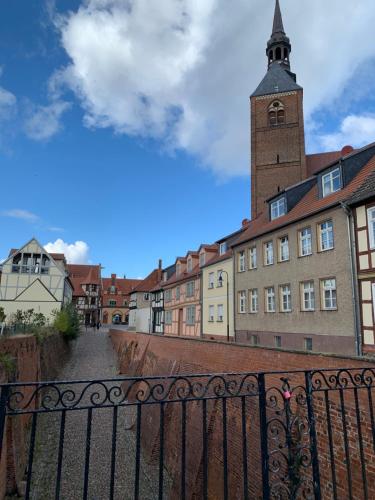 a building with a clock tower and a fence at Ringhotel Schloss Tangermünde in Tangermünde