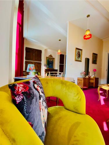 a yellow couch sitting in a living room at Le Rez de Jardin Albi in Albi