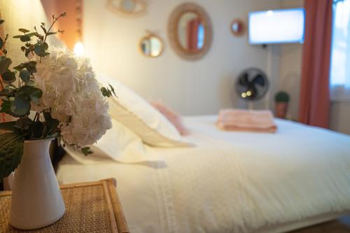 a bedroom with a bed with a vase of flowers on a table at Le Rez de Jardin Albi in Albi