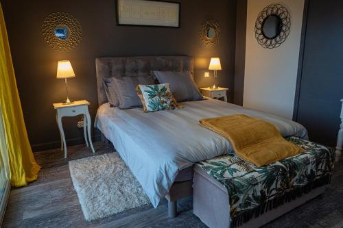a bedroom with a large bed and two tables and two lamps at Le Rez de Jardin Albi in Albi