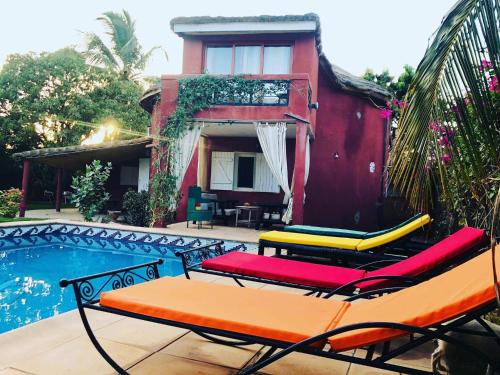 a group of chairs sitting next to a swimming pool at Carthago in Mbour