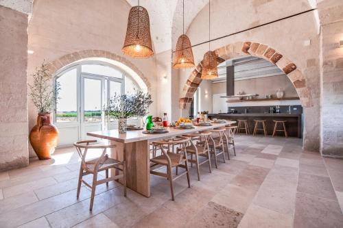 una cocina con una gran mesa de madera y sillas en Masseria Pezza, en Salice Salentino