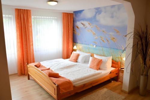 a bedroom with a bed with a painting on the wall at FEWO Vermietung Carmen Sagner in Baabe