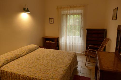 um quarto com uma cama, uma cómoda e uma janela em PODERE 31 em Santa Margherita di Pula