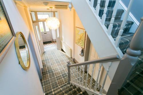 a hallway with a staircase with a mirror on the wall at Bryn Afon in Betws-y-coed