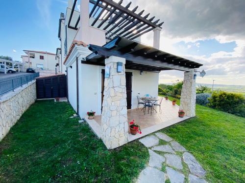 a house with a patio with a table and chairs at CASA VACANZA FELICITA' in Porto Potenza Picena