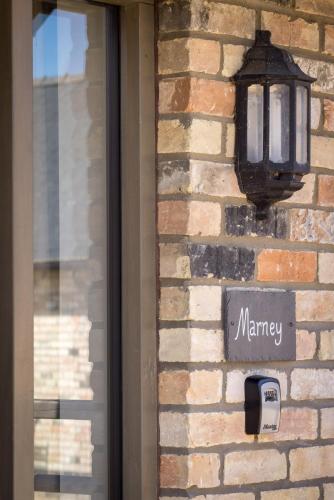 a sign on the side of a brick wall with a mailbox at Clopton Courtyard Cambridge in Cambridge