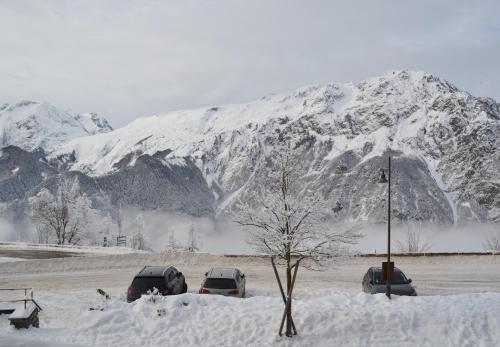 a snow covered mountain with cars parked in a parking lot at Granges 9 - Appartement vue époustouflante, au pied des pistes Domaine Alpe d'Huez in Villard-Reculas