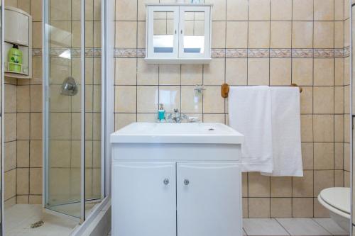 a bathroom with a white sink and a shower at Paradise View in Knysna