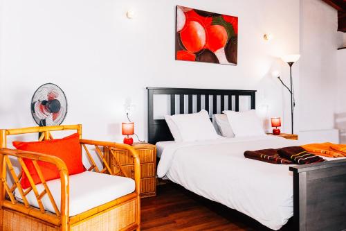 a bedroom with two beds and a chair at Casa Higuereta II in Corralejo